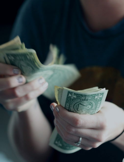 focus photography of person counting dollar banknotes