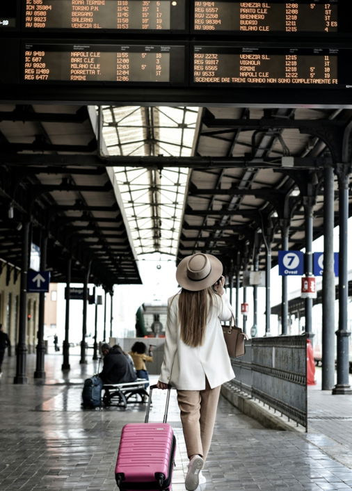 woman holding pink luggage